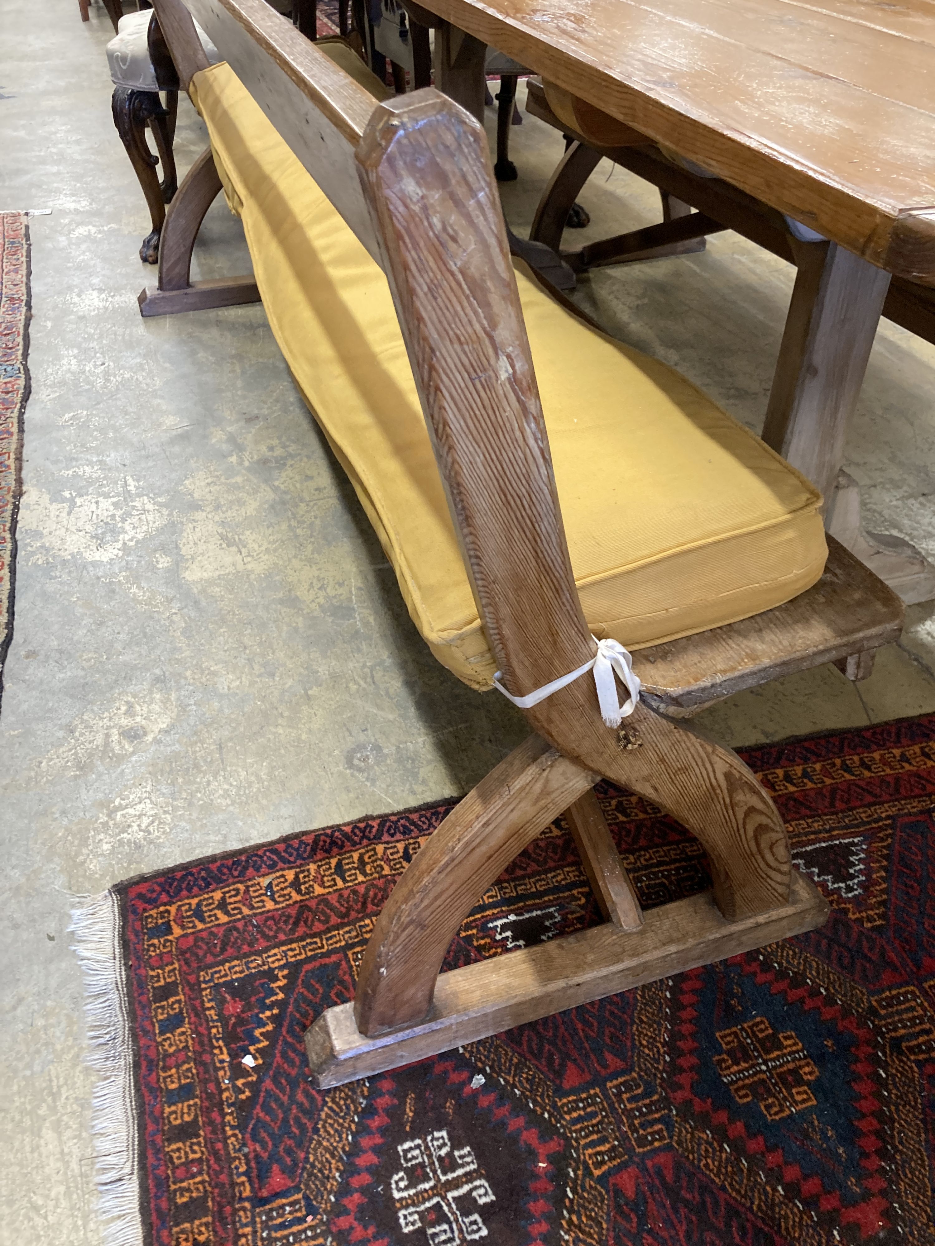 A rectangular pine kitchen table, width 218cm, depth 77cm, height 77cm together with a pair of Victorian pitch pine bench seats